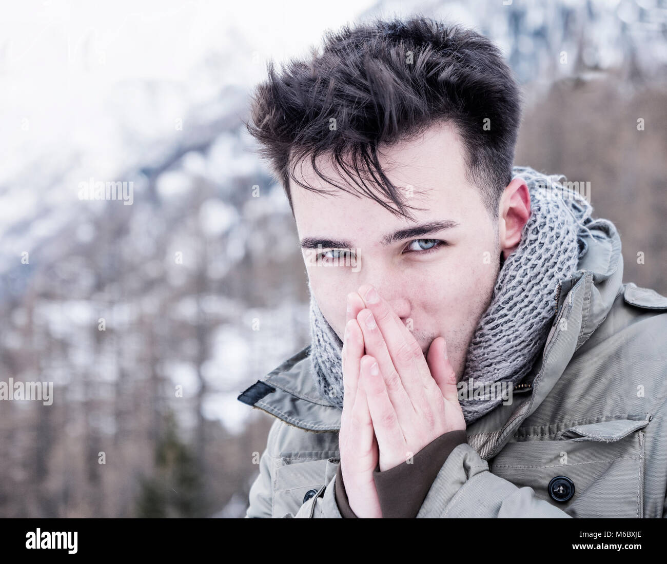 Junge Mann an der Kamera posiert im Schnee Stockfoto