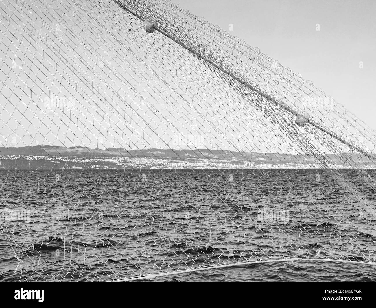 Kroatischen Adria an der Küste von Rijeka mit Fischernetz im Vordergrund in Schwarzweiß Stockfoto