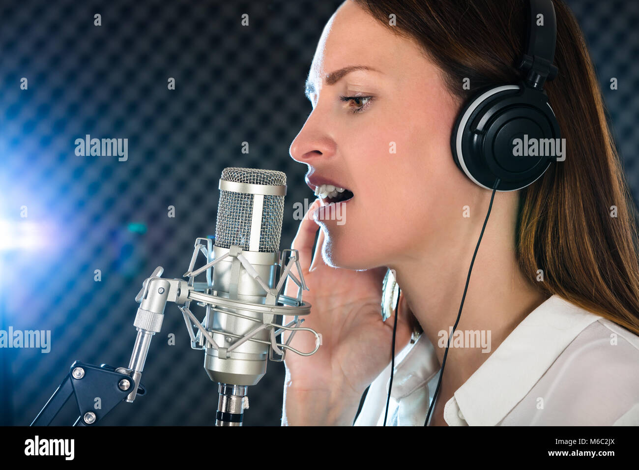 Nahaufnahme eines weiblichen offener Mund mit roten Lippenstift Vor Mikrofon Stockfoto