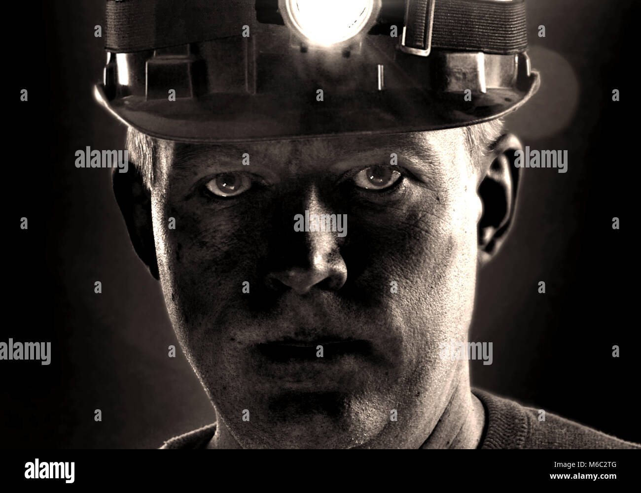 Müde schmutzige Gesicht der Coal Miner in Helm mit Licht. Ausführliches Porträt von mir Arbeiter. Stockfoto