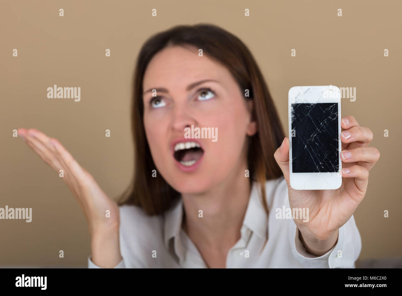 Nahaufnahme der unglücklichen Frau mit Smart Phone mit gebrochenen Bildschirm Stockfoto