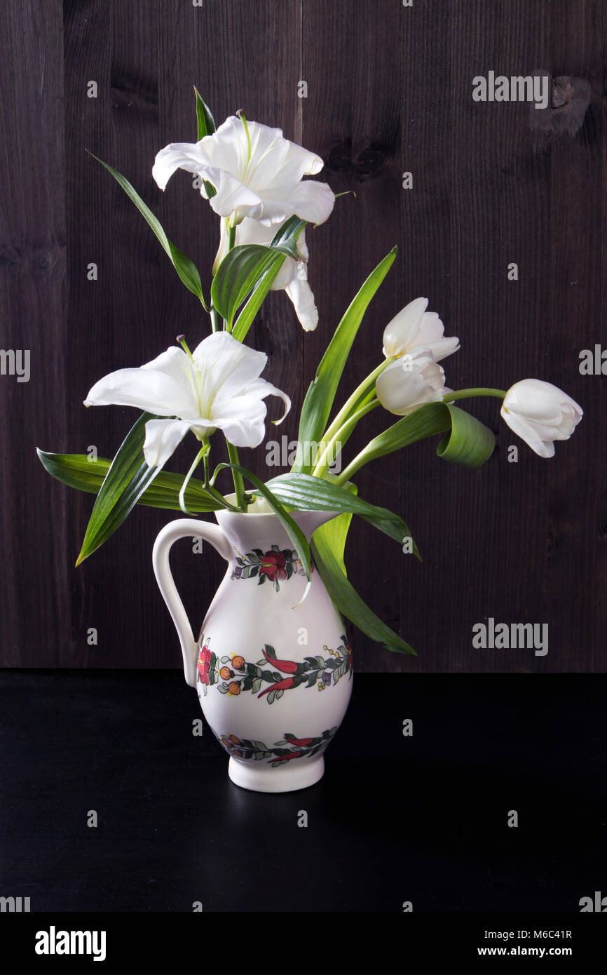 Wedding Bouquet von Lily abd Tulpen in einer Kanne auf schwarzem Hintergrund Stockfoto