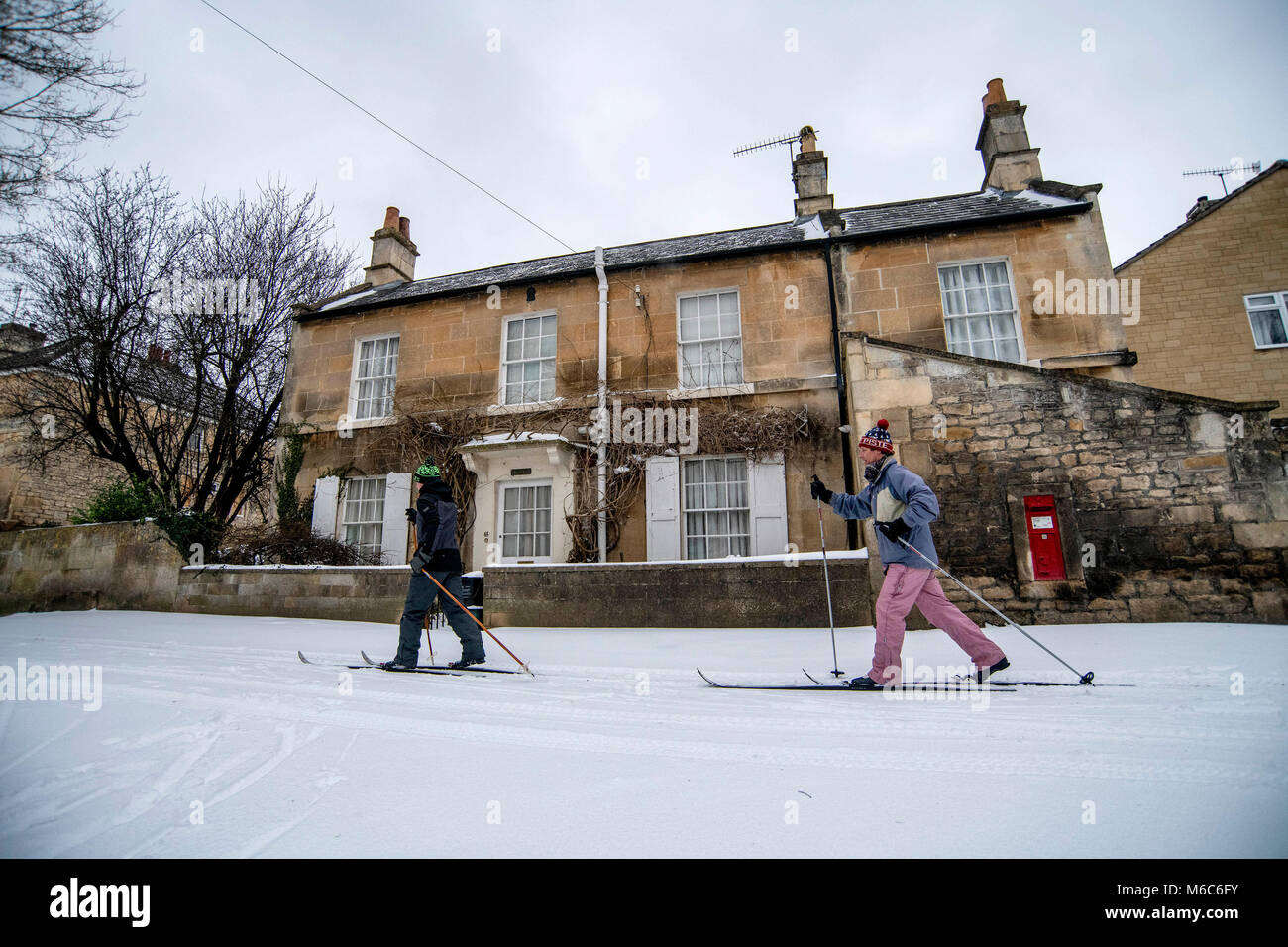 Zwei Mann Cross County Ski durch das Dorf Batheaston in der Nähe von Bath in Somerset nach starkem Schneefall. Tier aus dem Osten, Sturm Emma. Stockfoto