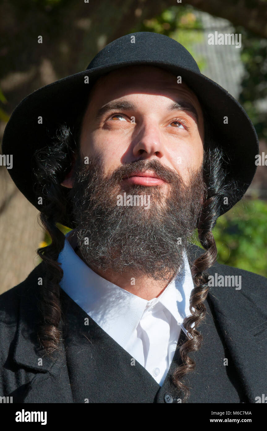 Außenbereich sonnige Porträt einer jungen orthodoxen jüdischen Mann mit schwarzen Bart und Hut suchen Stockfoto
