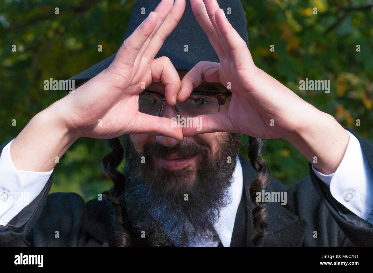 Was ist Judentum und wie echte jüdisch-orthodoxen sollte Kleidung und Aussehen. Außenbereich sonnige Porträt einer jungen lächelnd emotionale glücklich Segen mit Herz Stockfoto