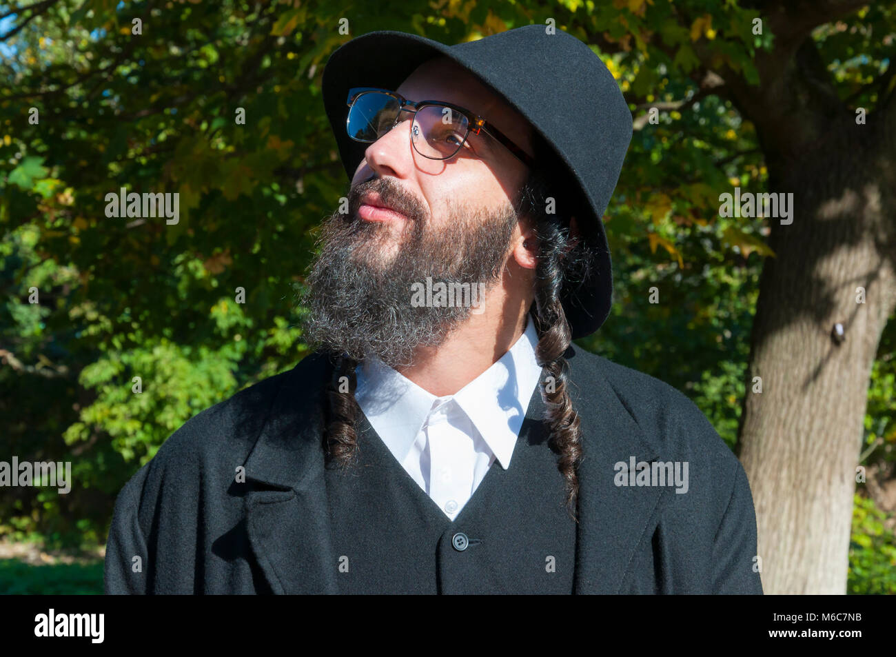 Außenbereich sonnige Porträt einer jungen orthodoxen jüdischen Mann mit schwarzen Bart und Hut in den Himmel suchen Stockfoto