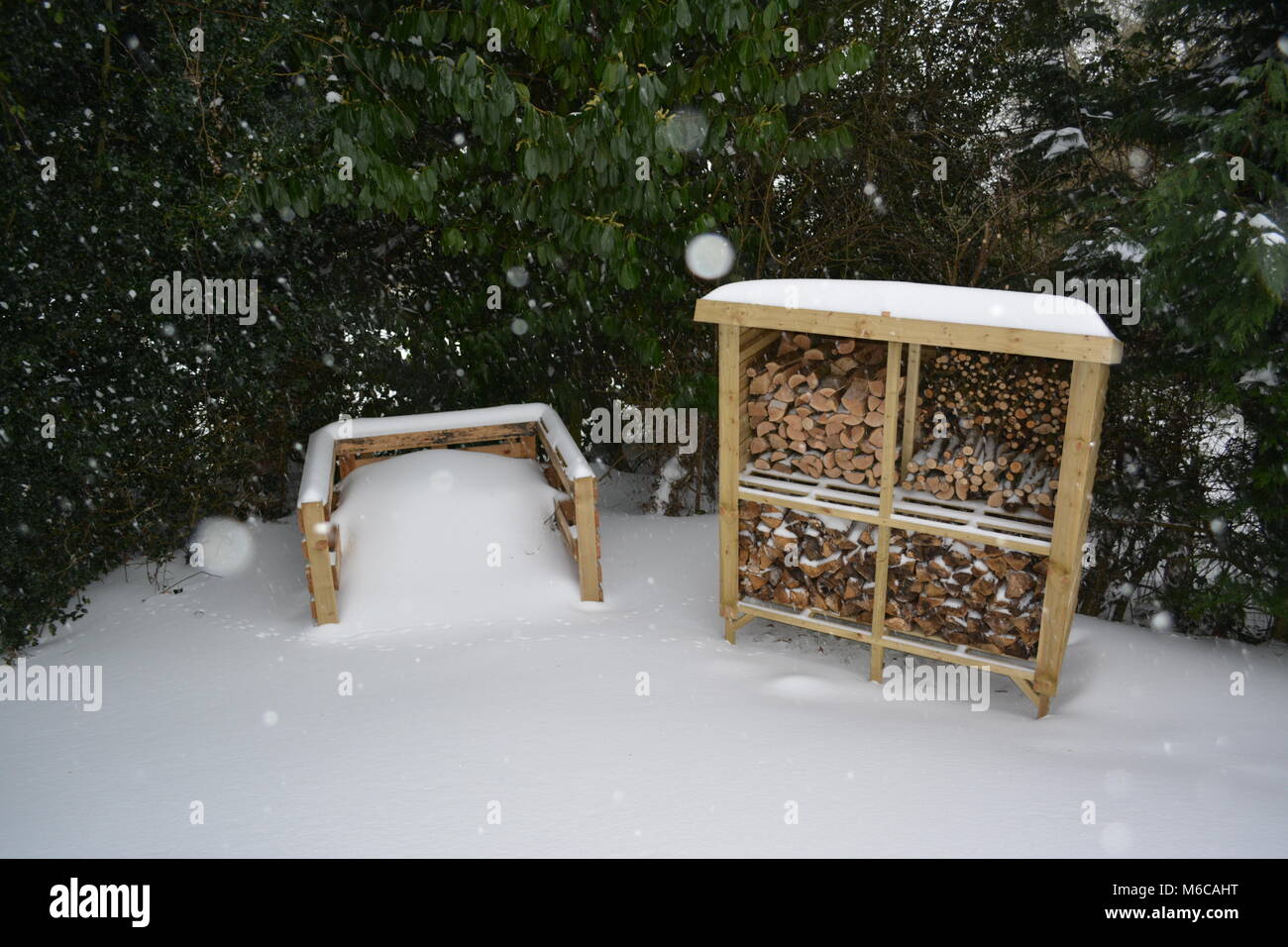 Store anmelden mit einem mono pitch Dach im Garten aus behandeltem Holz und Komposthaufen gebildet, der erneut verwendeten Paletten mit starker Schneefall bedeckt Stockfoto