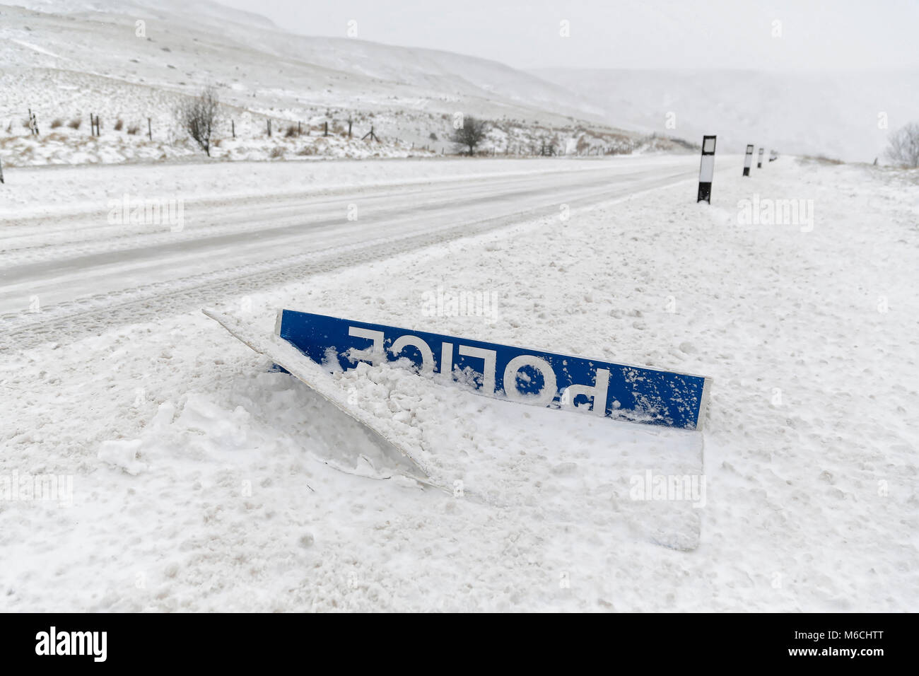 Wetter BILD WALES im Bild: Eine 'Polizei Langsam' Zeichen durch Schnee an der Seite des A470 Weg bedeckt in der Geschichte Waffen, Brecon Beacons in South Wales, UK. F Stockfoto