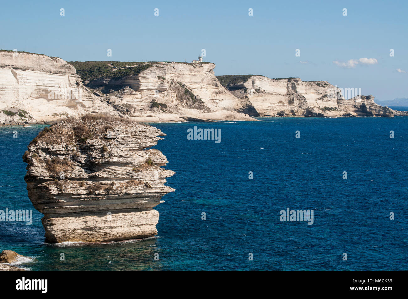 Korsika: Die atemberaubenden weißen Kalksteinfelsen in der Internationalen Bouches de Bonifacio marine Park mit Blick auf das Kap Pertusato Leuchtturm Stockfoto