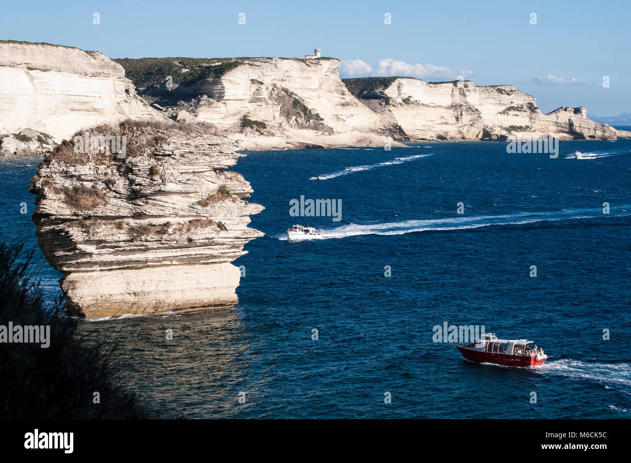 Korsika: ein Boot mit Blick auf die atemberaubenden weißen Kalkfelsen von Bonifacio vor der Meerenge von Bonifacio Stockfoto