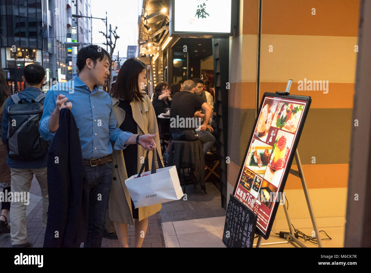 Paar prüfen ein Restaurant Menü in Ginza, Tokyo, Japan Stockfoto