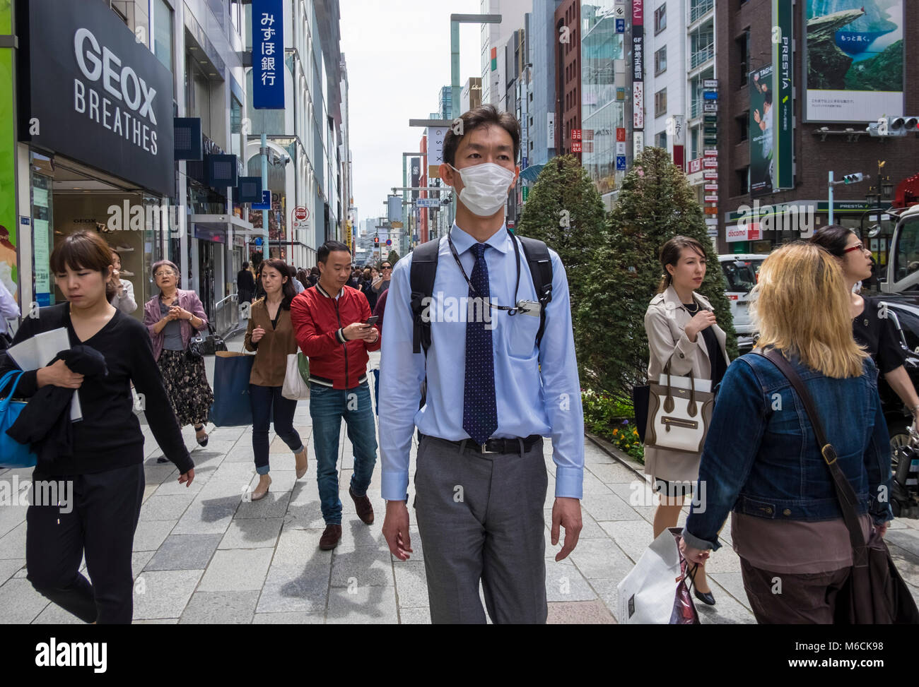 Der Mann trägt eine Coronavrius-Maske auf der Straße im Stadtteil Ginza in Tokio, Japan Stockfoto
