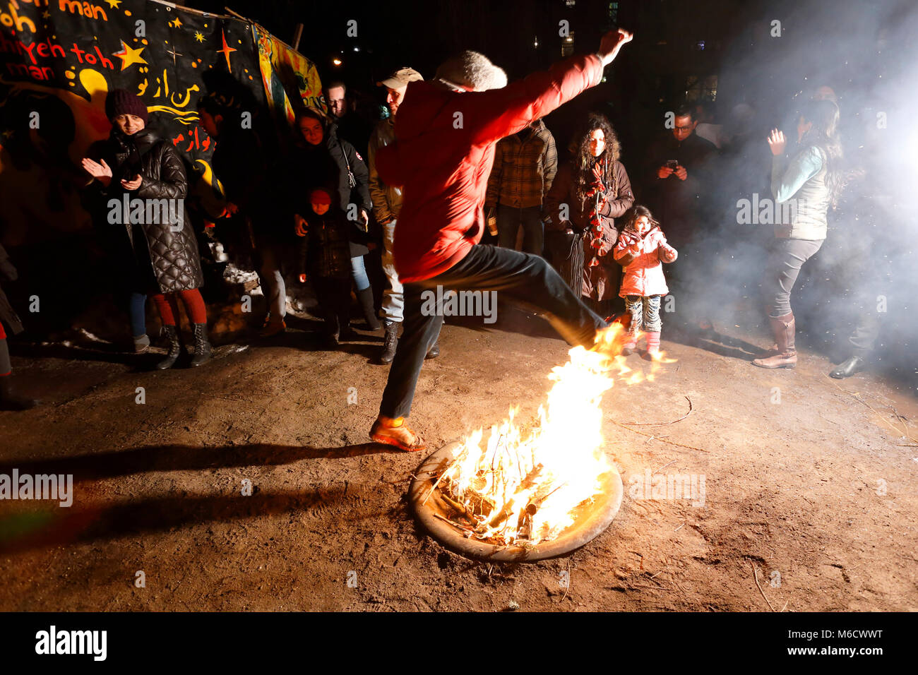 Die Leute feiern Charshanbe Suri, das Feuerfestival zu Beginn des persischen Neujahrs mit Feuerspringen in einem Gemeindegarten von NYC, 17. März 2017 Stockfoto