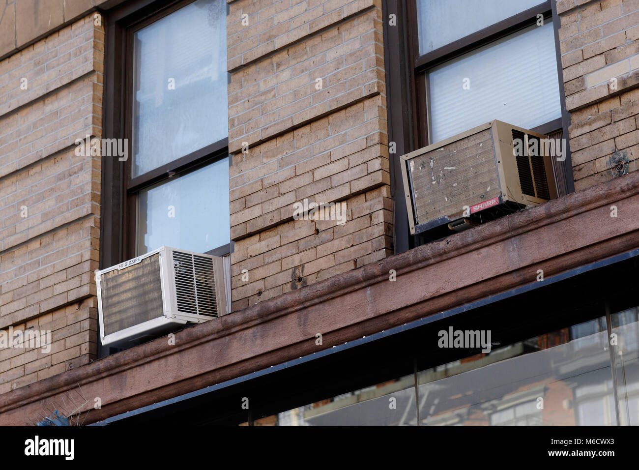 Klimageräte prekär gehockt auf New York City Fensterleisten Stockfoto