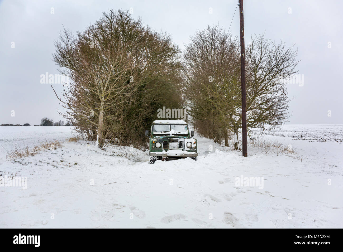 Hoxne, Suffolk. 2. März 2018. Noch immer leidet das Tier aus dem Osten. Sogar ein Land Rover hat nicht durch die schneewehen Auf dieser Landstraße zu fahren aufgegeben. Stockfoto