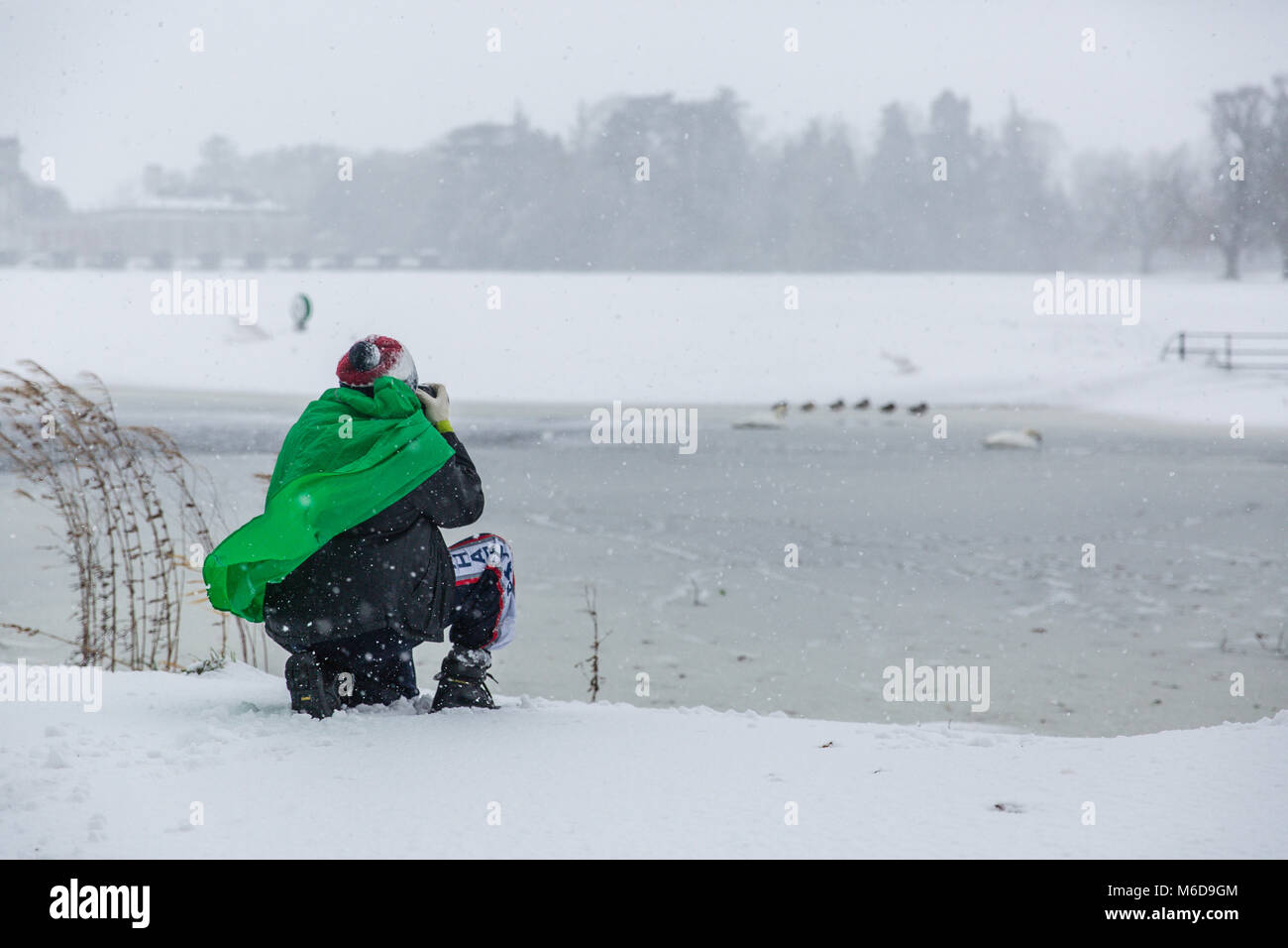 Celbridge, Kildare, Irland. 02 Mär 2018: der Mann, der Fotograf mit Canon Ausrüstung Fotos von Stockenten, stehend auf einem gefrorenen Teich auf der überdachten im Schnee Castletown Park in Celbridge. Tier aus dem Osten durch Sturm Emma brachte Schnee und starkem Wind lähmt das Land und zwingen die Met Éireann die rote Warnmeldung über Irland zu erteilen. Stockfoto