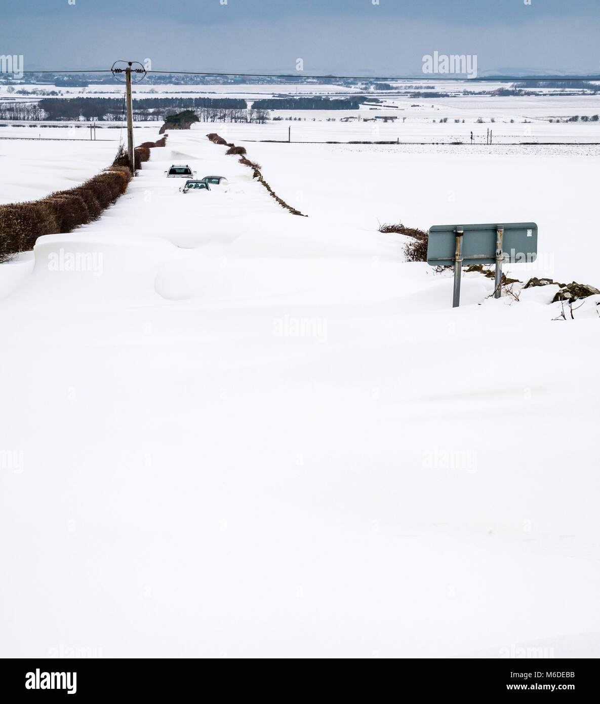 East Lothian, Schottland, Vereinigtes Königreich, 3. März 2018. UK Wetter: Die lokale Straße zwischen Drem und Haddington wird durch große Schneeverwehungen mit mehreren Autos geschlossen bis zu den Dächern begraben nach dem extremen arktischen Wetter event Spitznamen "das Tier aus dem Osten' Stockfoto