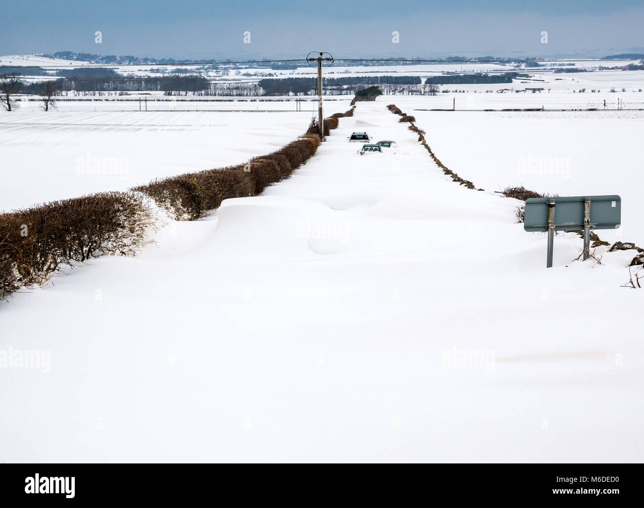 East Lothian, Schottland, Vereinigtes Königreich, 3. März 2018. UK Wetter: Die lokale Straße zwischen Drem und Haddington wird durch große Schneeverwehungen mit mehreren Autos geschlossen bis zu den Dächern begraben nach dem extremen arktischen Wetter event Spitznamen "das Tier aus dem Osten' Stockfoto