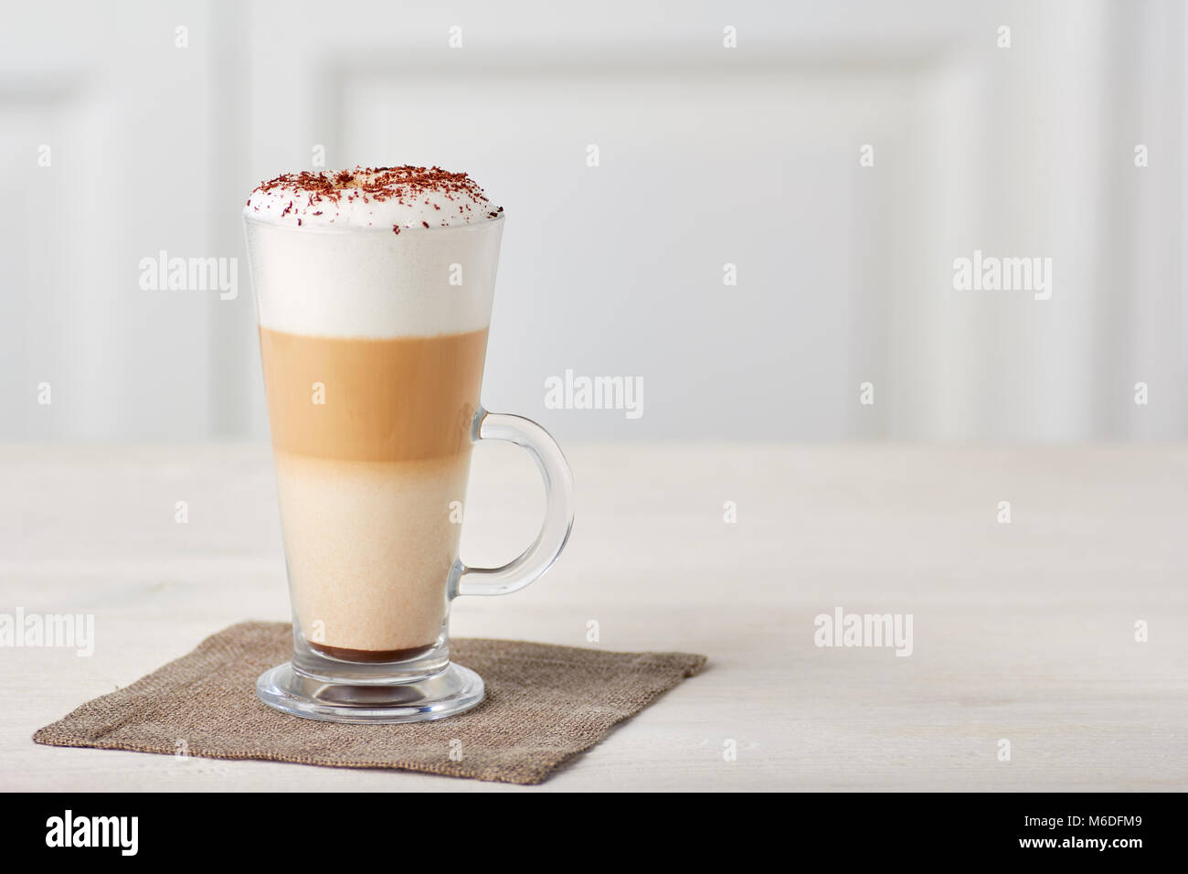 Glas Tasse Kaffee Latte auf hölzernen Tisch Stockfoto