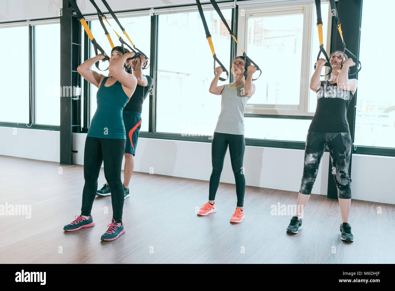 Team von Fitness TRX Suspension gurte Übungen asiatischen Menschen tun das Hochziehen, arbeiten mit eigenen Gewicht an der Turnhalle. Stockfoto