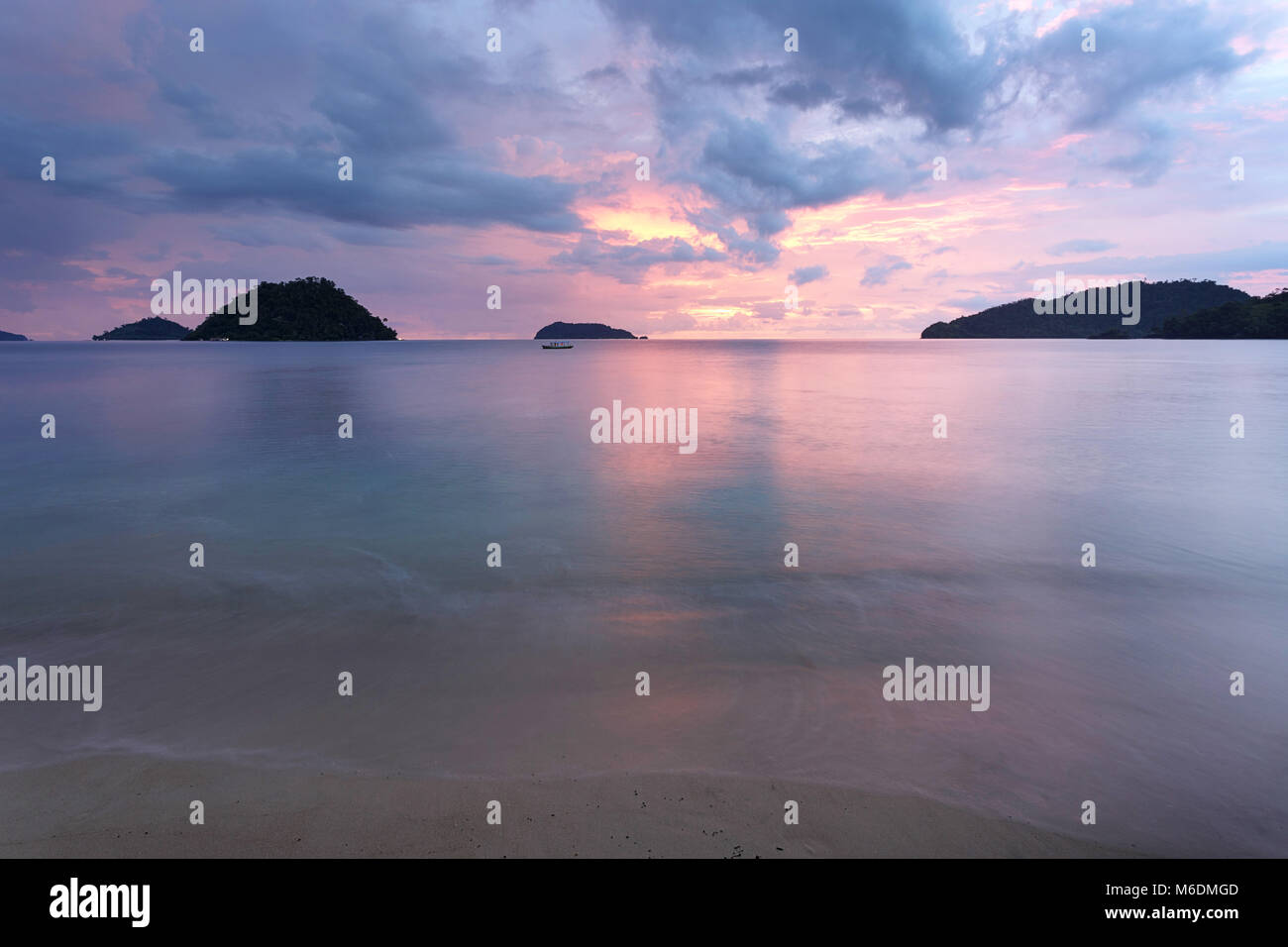 Schönen tropischen Sandstrand bei Sonnenuntergang mit rosa Farben Stockfoto