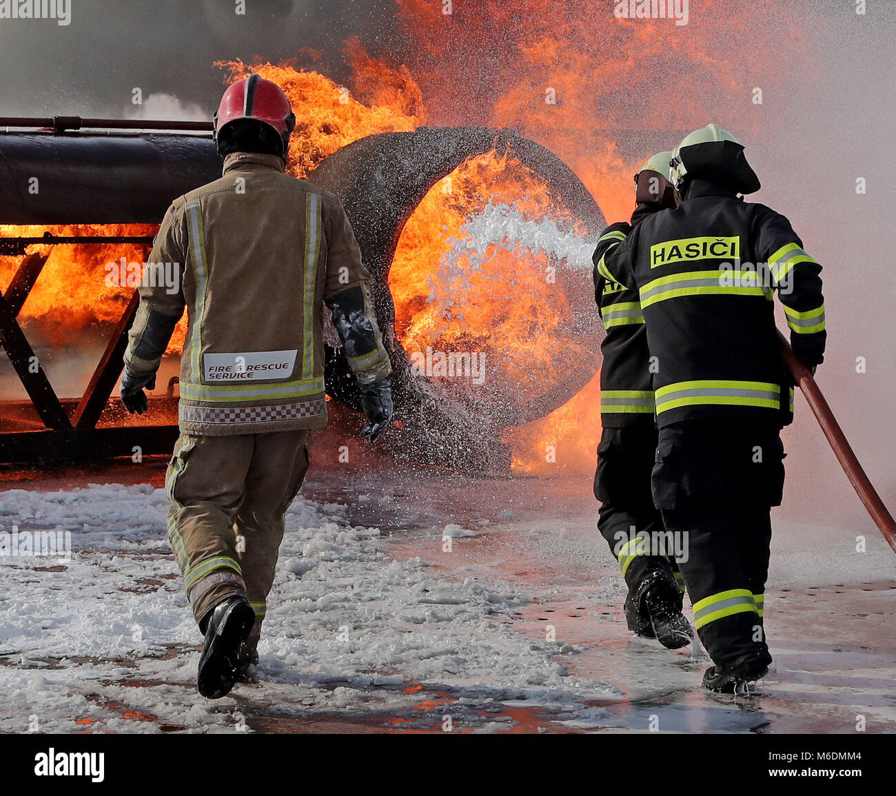 Mitglieder der slowakischen Luftwaffe (rechts) erfahren im RAF Manston Defence Fire Training & Development Centre in Ramsgate, Kent, wie man zum ersten Mal größere Flugzeugbrände in Großbritannien auslöst. Stockfoto