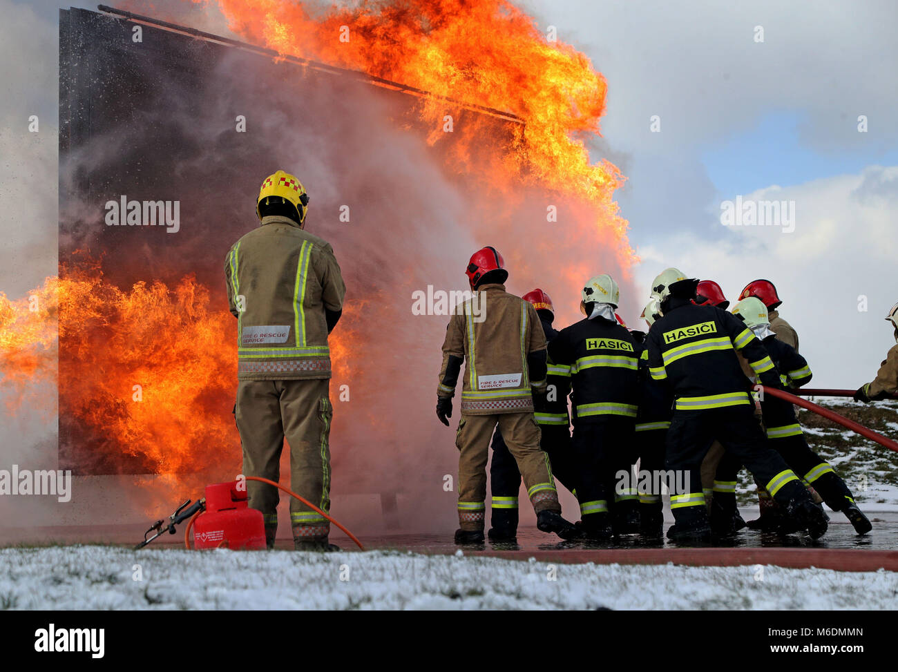 Im RAF Manston Defence Fire Training & Development Centre in Ramsgate, Kent, erfahren Mitglieder der slowakischen Luftwaffe (dunkelblau) zum ersten Mal, wie man große Flugzeugbrände in Großbritannien auslöst. Stockfoto