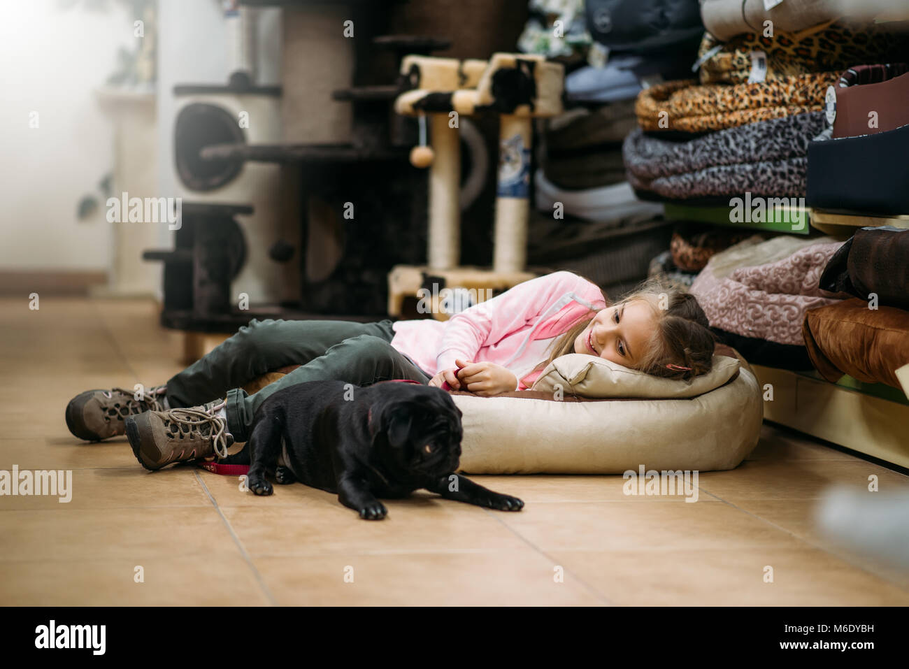 Kleines Mädchen mit Welpen sind Schlafen in Pet Shop. Kind mit Hund in petshop, für den inländischen Tiere Stockfoto