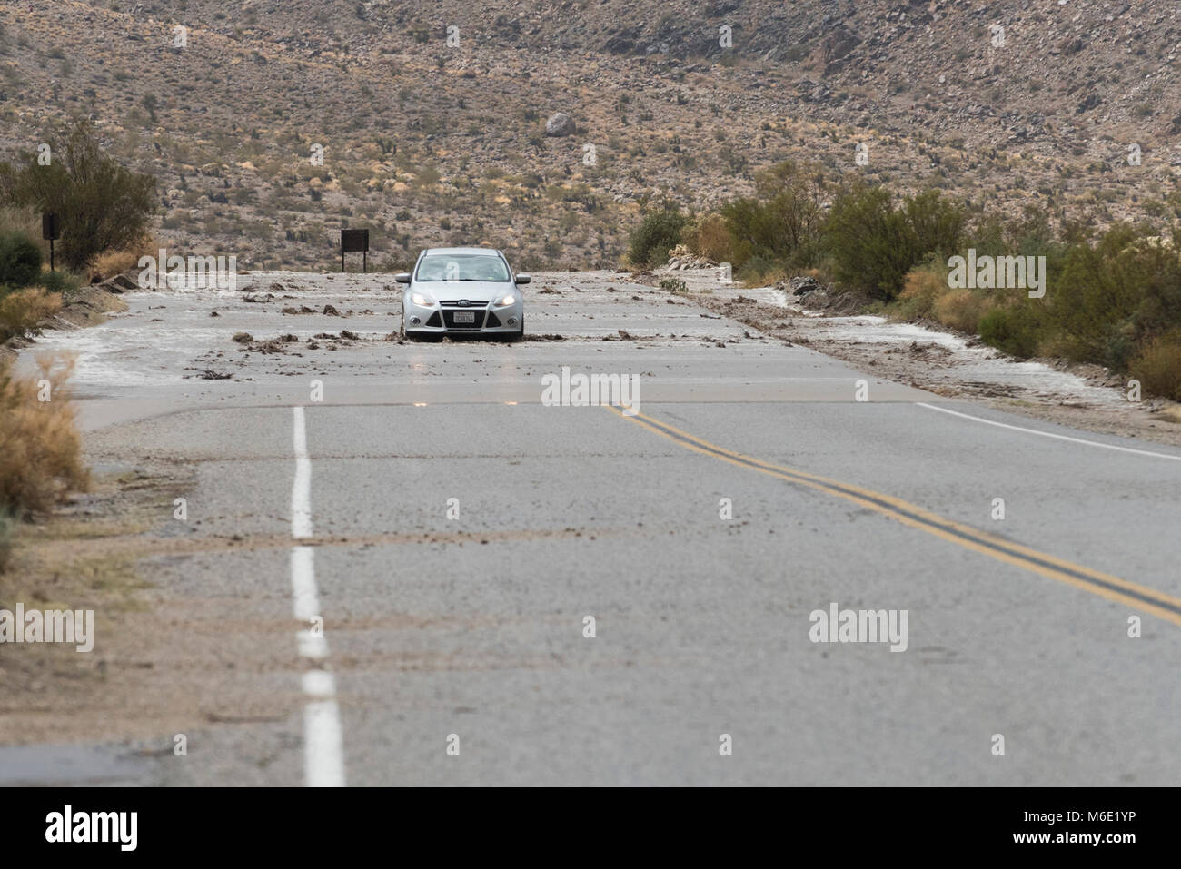 Ein Besucher Antriebe durch das Wasser auf der Straße; 82615. Stockfoto