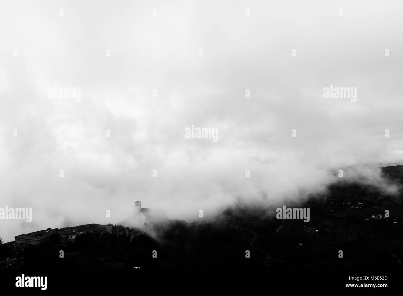 Blick auf die St. Francis päpstliche Kirche in Assisi (Umbrien, Italien) in der Mitte der Aufhebung Morgennebel Stockfoto
