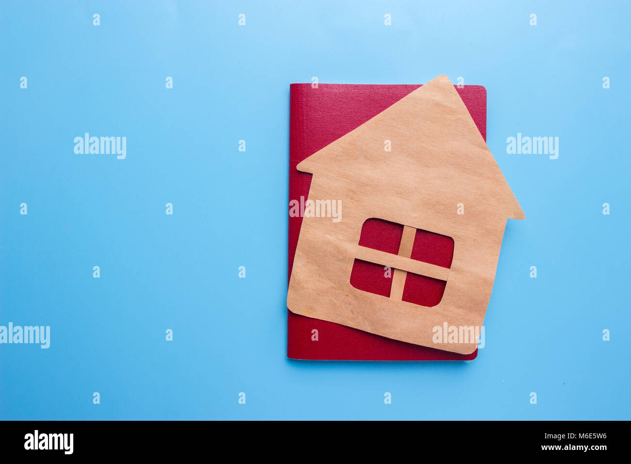 Reisepass und dem Haus auf blauen Hintergrund. Erwerb der Staatsangehörigkeit Konzept Stockfoto