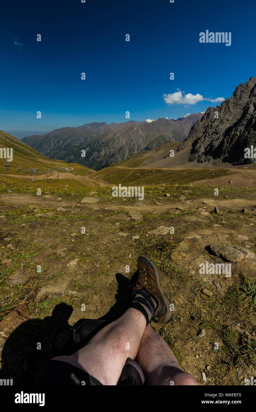 Tien Shen Berge bei Shymbulak oberen Piste Talgar Pass in der Nähe von Almaty, Kazakhstanl Beine im Vordergrund. Stockfoto