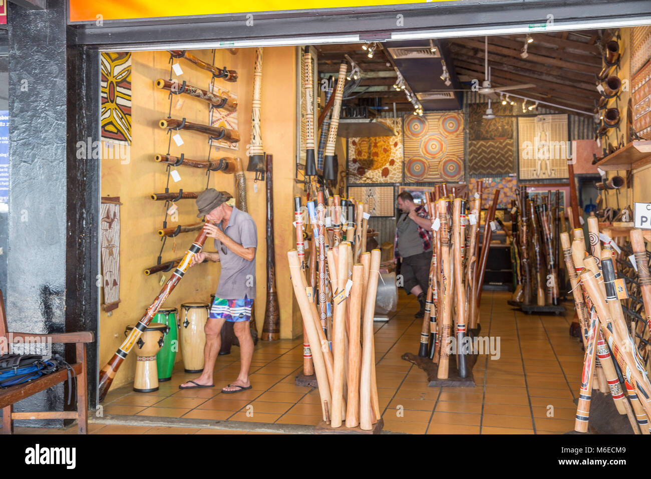 Mann spielt ein Didgeridoo Musical Instrument in einem Geschäft in der Innenstadt von Cairns entfernt, Far North Queensland, Australien Stockfoto