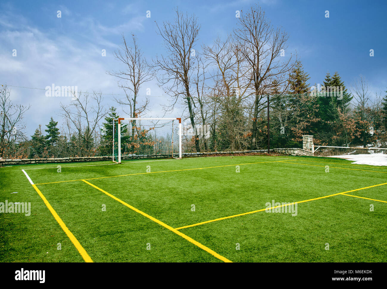 Feld für Fußball und andere Sportarten unter blauem Himmel mit Wolken im Winter Stockfoto