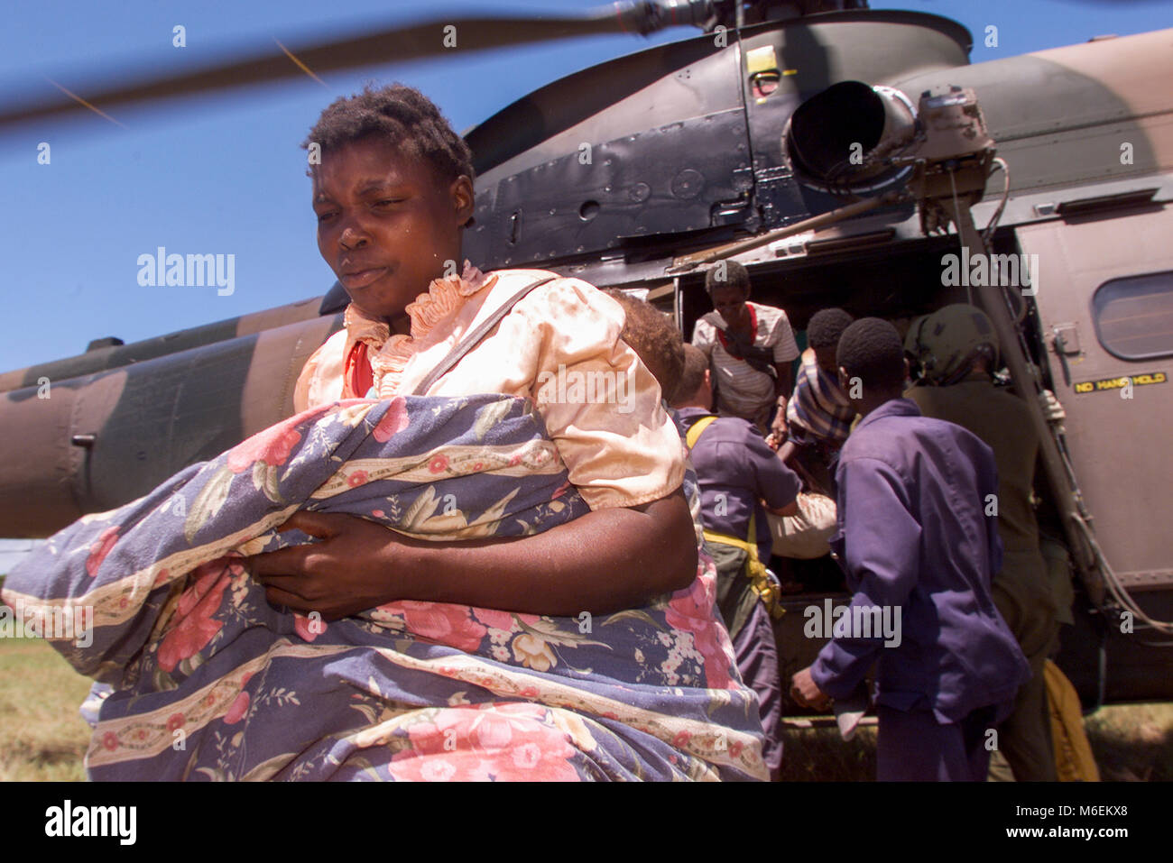 Überschwemmungen in Mosambik, März 2000; Gerettete Leute laufen in Sicherheit nach einem Südafrikanischen Hubschrauber sie auf hohe Boden in der Nähe von Gaza Chibuto, Provinz fällt. Stockfoto