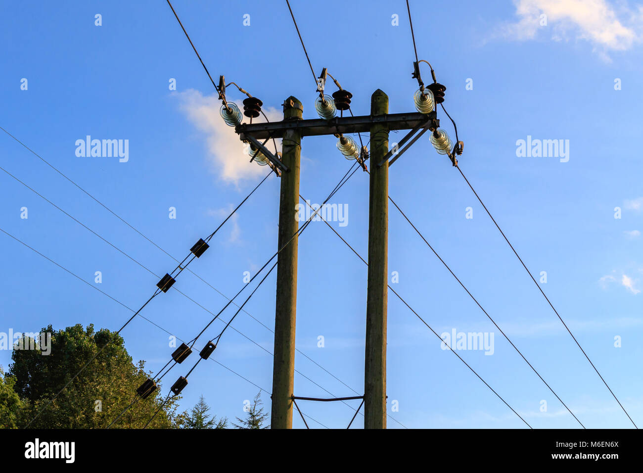 Elektrische Überlandleitungen repariert Holzpfähle mit einem blauen Himmel Hintergrund Stockfoto