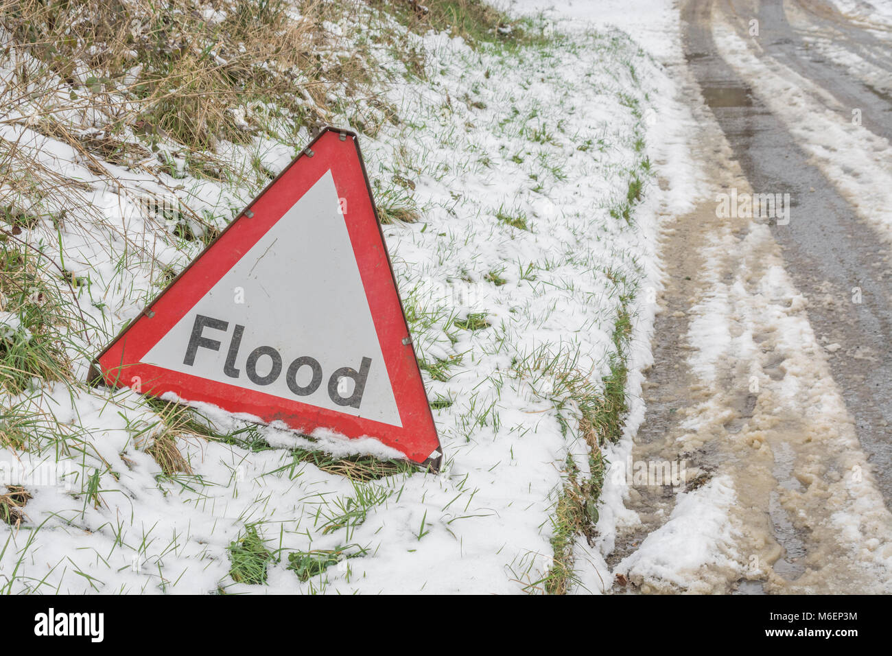 Die Anomalie eines roten Flut Warnung Schild während der Schnee des 2018 "Tier aus dem Osten' - in Looe, Cornwall. Stockfoto