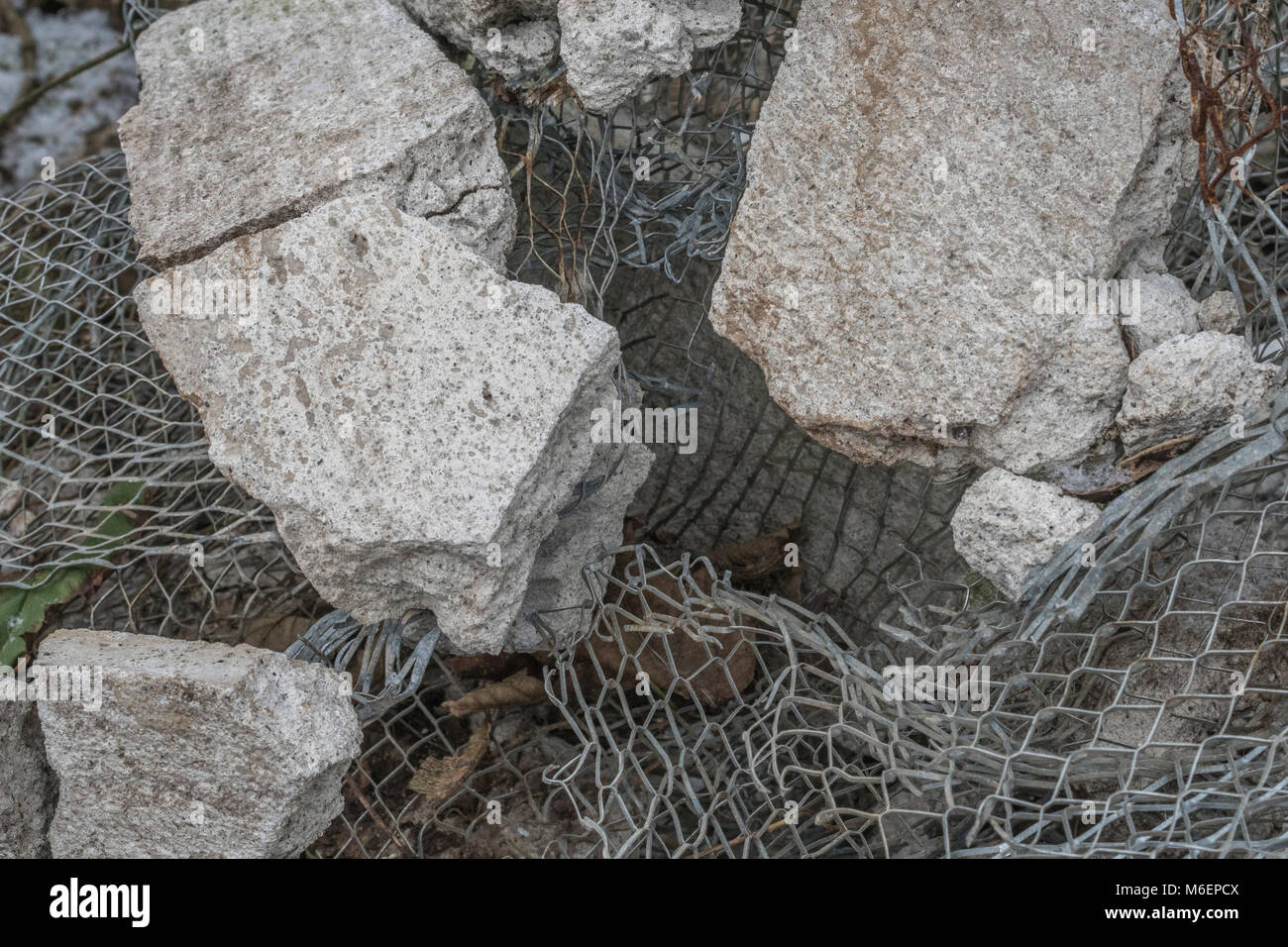 In der Nähe von mesh und Beton bei rubble Pile ist ein Builder. Metapher für in Stücke zerbrochen, in Fetzen, in Stücke zerschlagen. Stockfoto