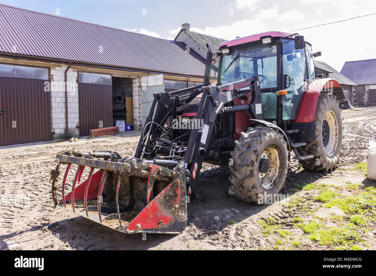 Landwirtschaftliche Maschinen und Anlagen. Traktor mit Frontlader für Gülle. Der Hof von einem Milchviehbetrieb. Podlachien, Polen. Stockfoto