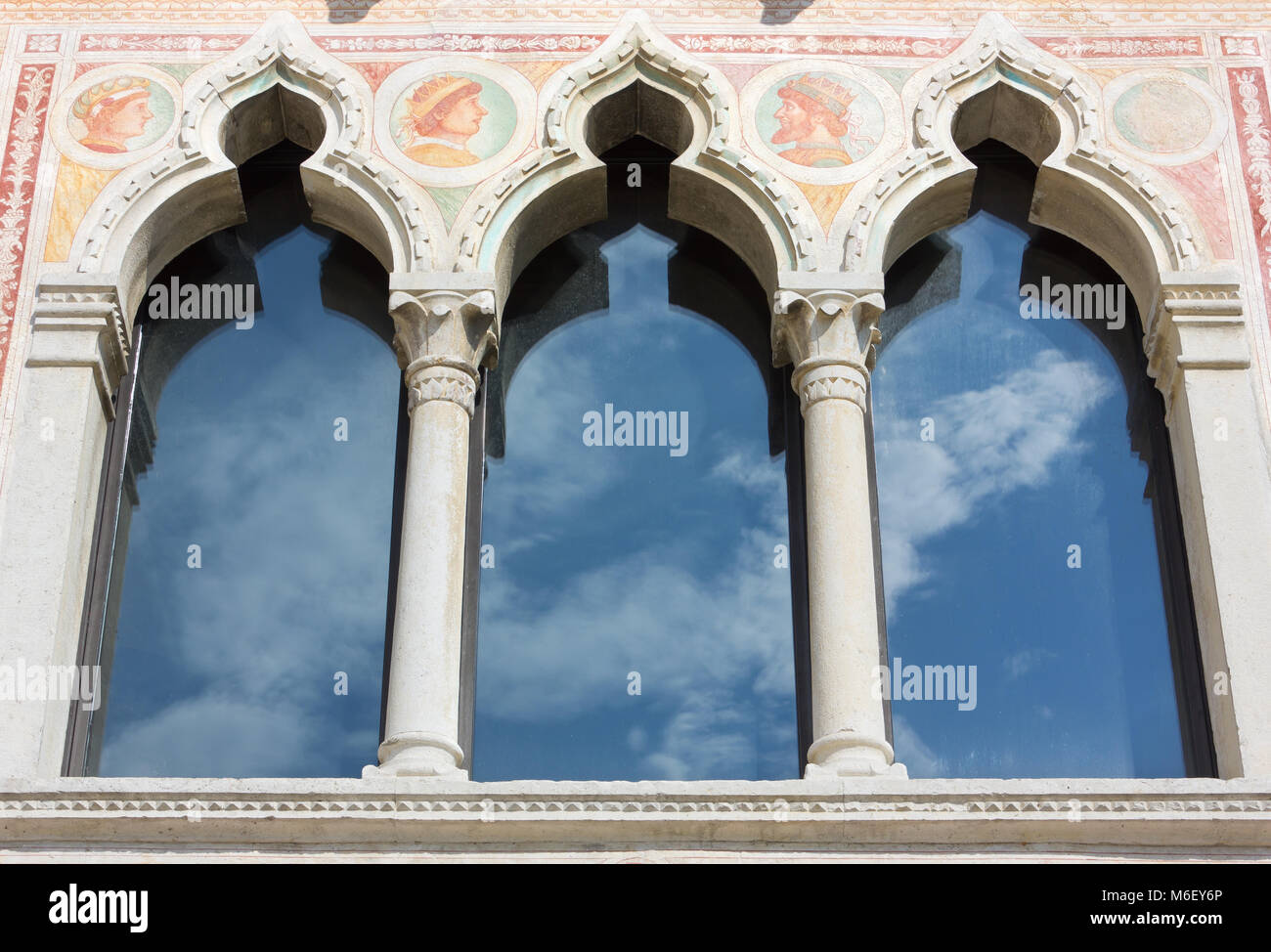 Fenster mit Fensterkreuz mit Fresken an der Fassade des Schlosses von Spilimbergo, Italien eingerichtet Stockfoto