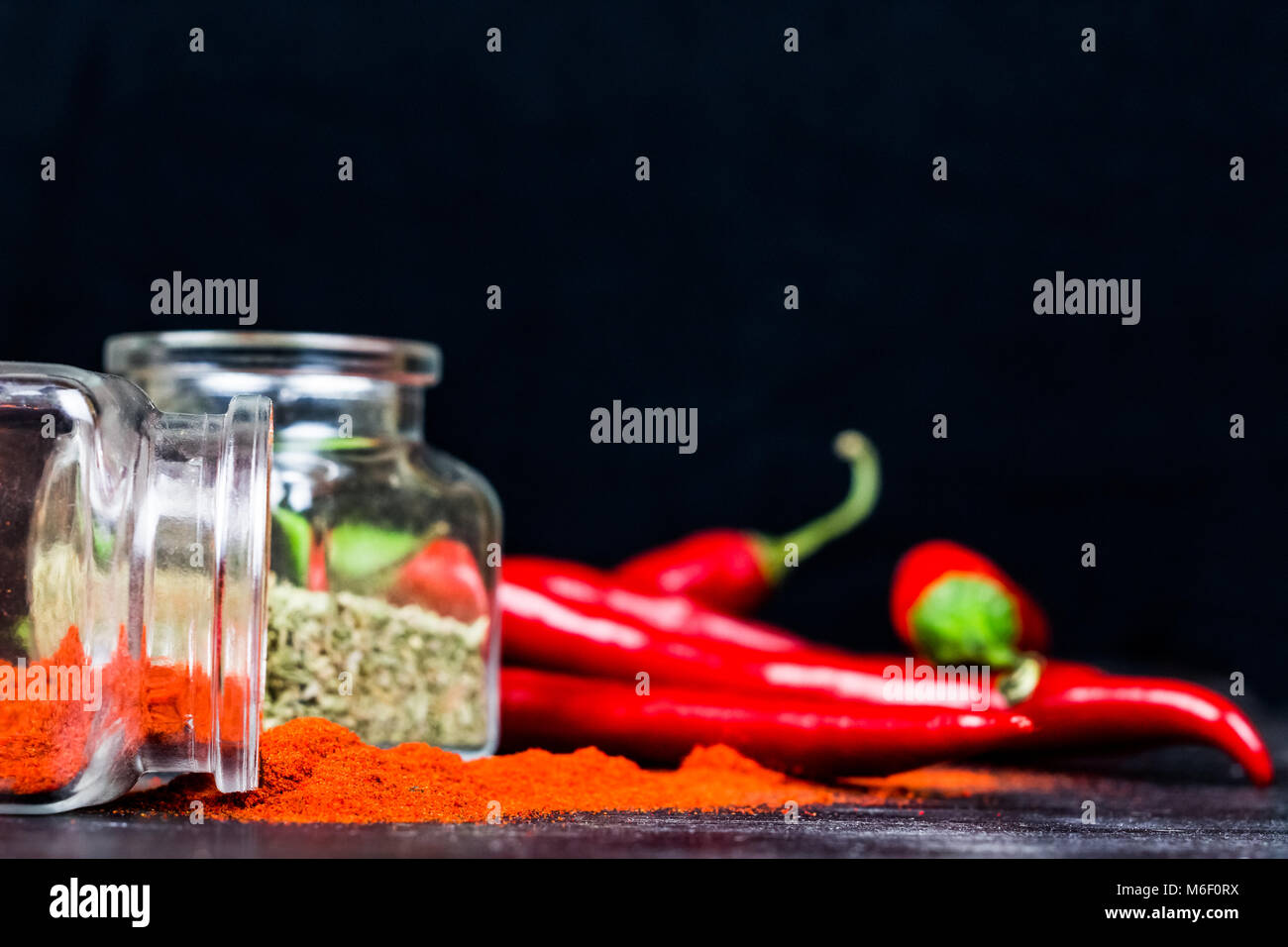 Chili Pulver, chemische Basilikum und Chili peppers auf schwarz Tabelle Stockfoto
