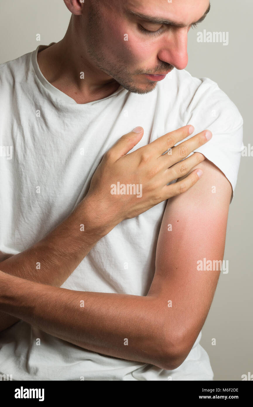 Unzufriedenheit Mann untersucht Farmer's Tan auf seinen Händen Stockfoto