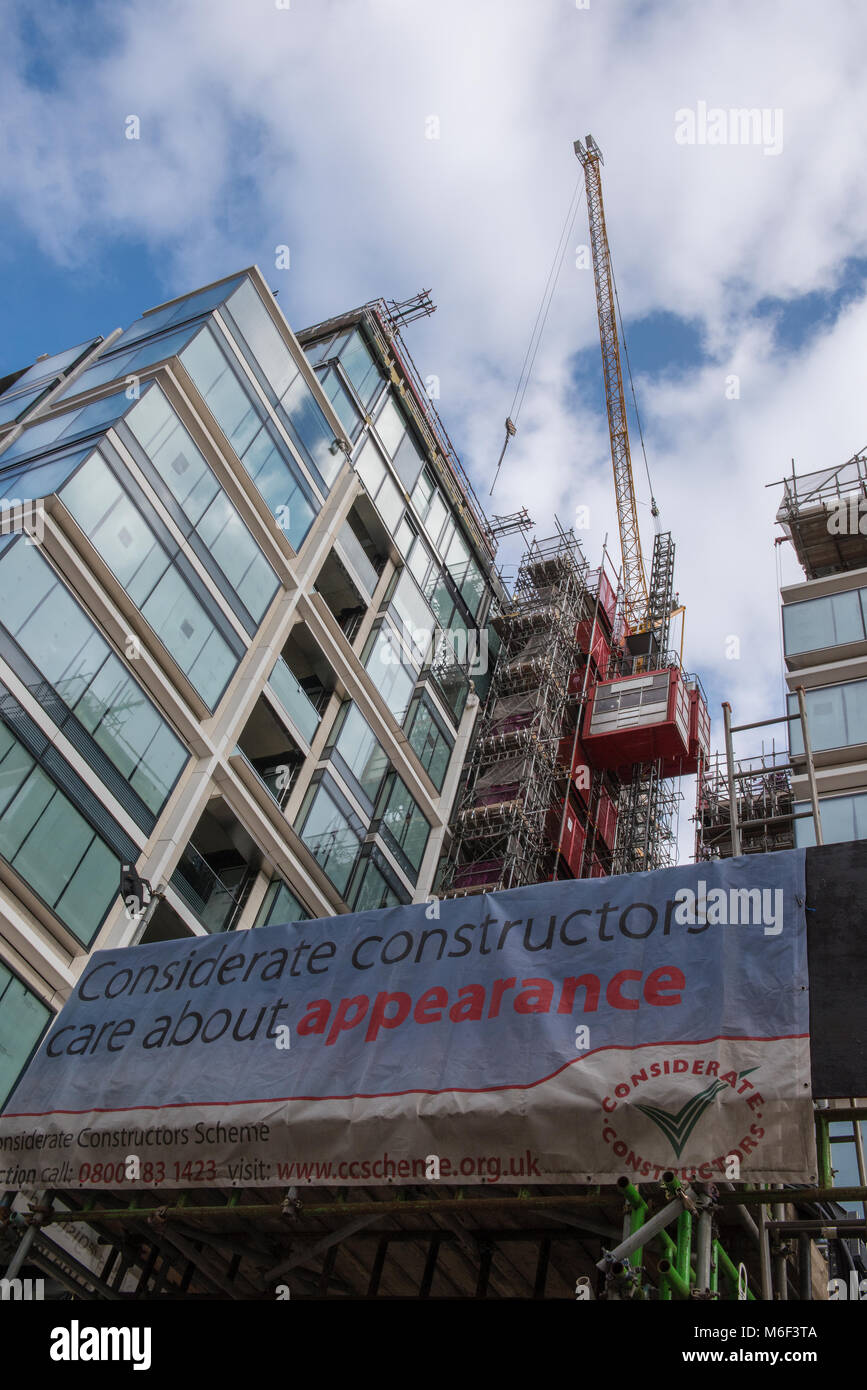 Rücksichtsvoll Konstruktoren Banner vor einer Baustelle für einige neue bauen Wohnungen oder Wohnungen in Central London. Kräne und Aufzüge arbeiten vor Ort Stockfoto