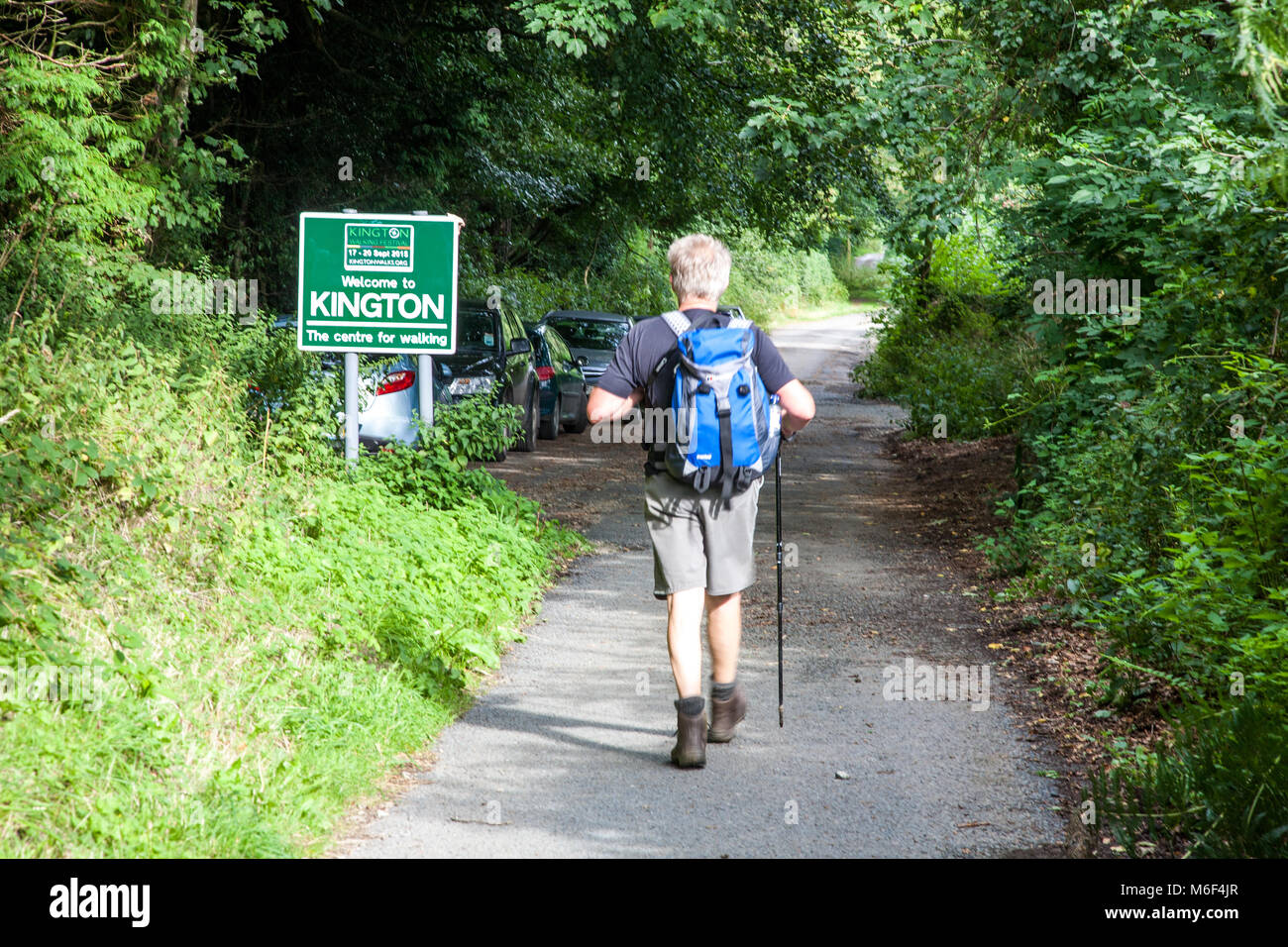 Mann, der Rucksack zu Fuß in die Stadt von Kington Powys beim Gehen auf der Offa's Dyke lange Distanz nationalen Wanderweg Wanderweg Stockfoto