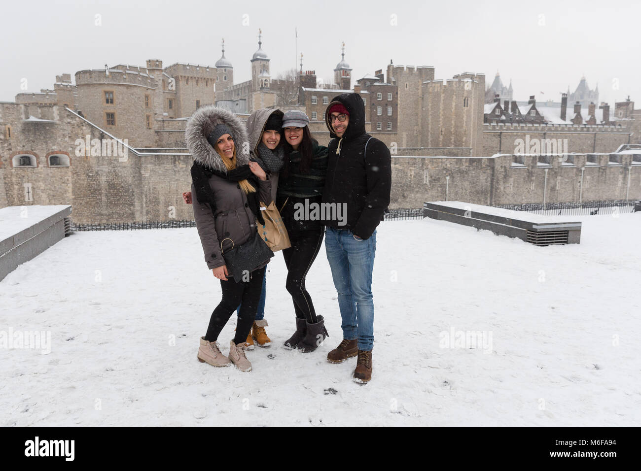 London, Großbritannien. 2. März 2018. Eine Gruppe von Touristen aus Italien für ein Foto vor dem Tower von London während Snow Fall in London, England am 2. März 2018 wie Frost, daß das "Tier aus dem Osten' kombiniert mit Sturm Emma haben Schnee und Frost nach Großbritannien gebracht. Stockfoto