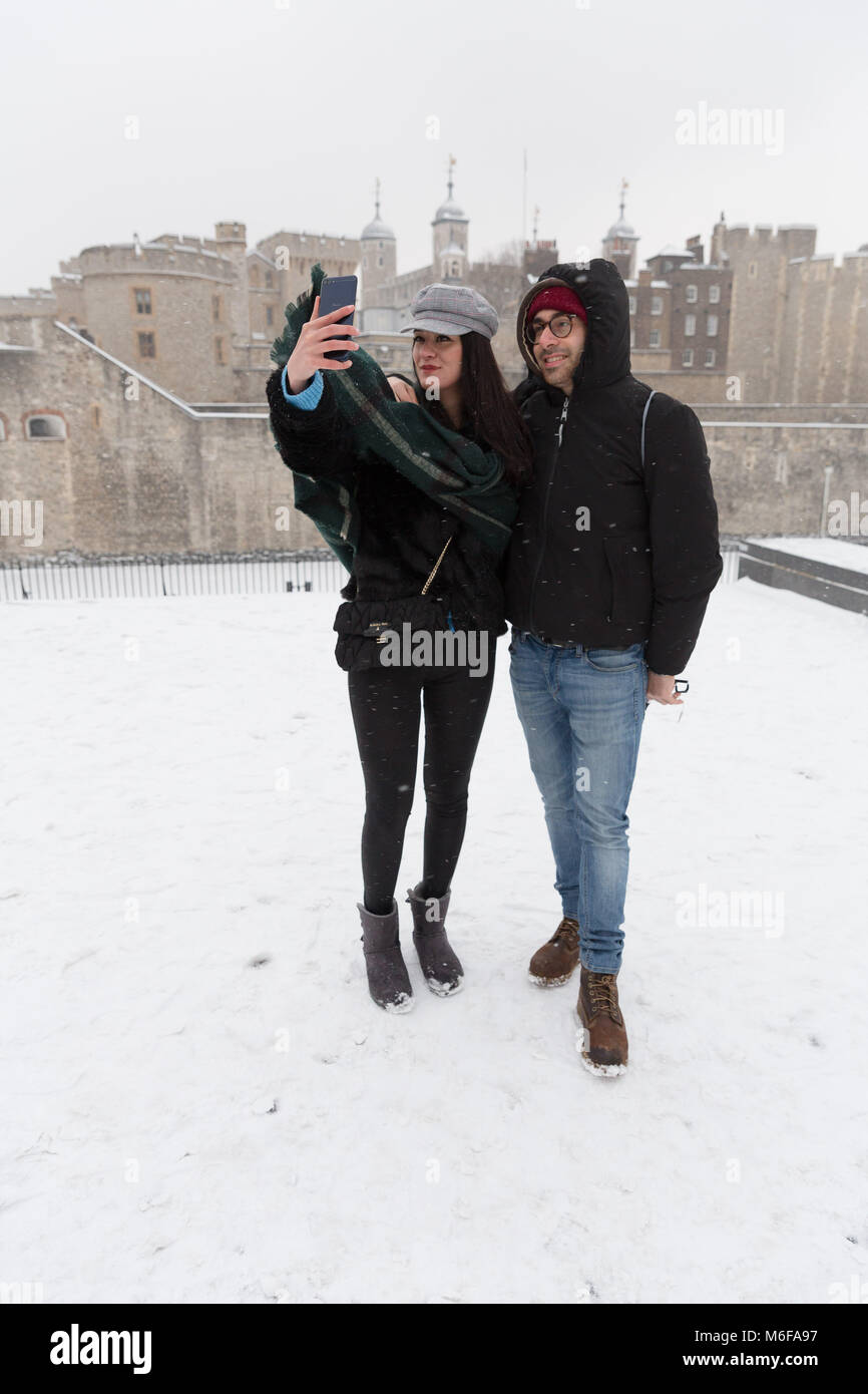 London, Großbritannien. 2. März 2018. Ein Paar aus Italien für eine selfie vor dem Tower von London während Snow Fall in London, England am 2. März 2018 wie Frost, daß das "Tier aus dem Osten' kombiniert mit Sturm Emma haben Schnee und Frost nach Großbritannien gebracht. Stockfoto