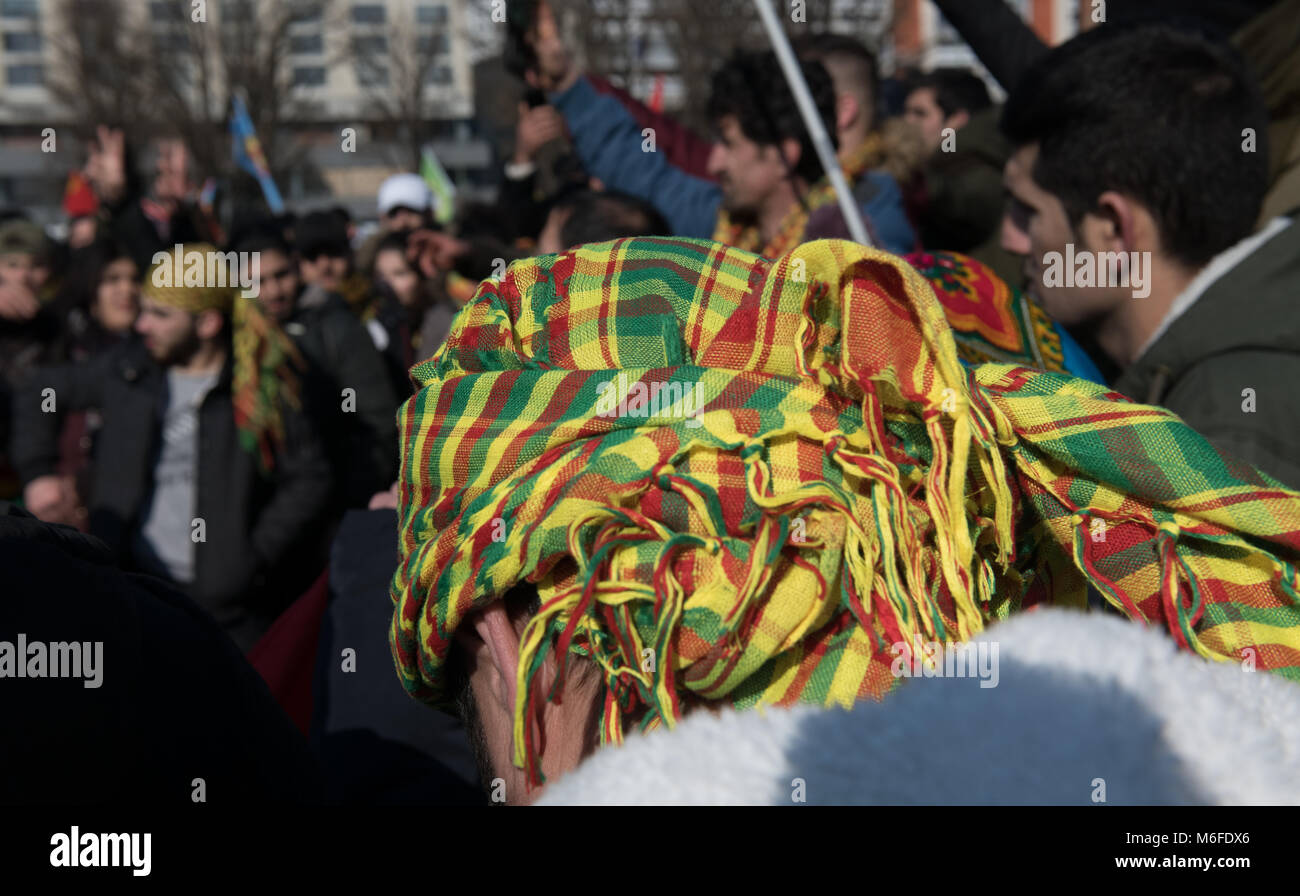 03 März 2018, Deutschland, Berlin: Ein Mann trägt die kurdische Fahne als Kopftuch in einer Demonstration von türkischen Aggressionen in der syrischen Provinz Afrin, wo die Mehrheit der Bevölkerung kurdischen ausgelöst. Foto: Paul Zinken/dpa Stockfoto