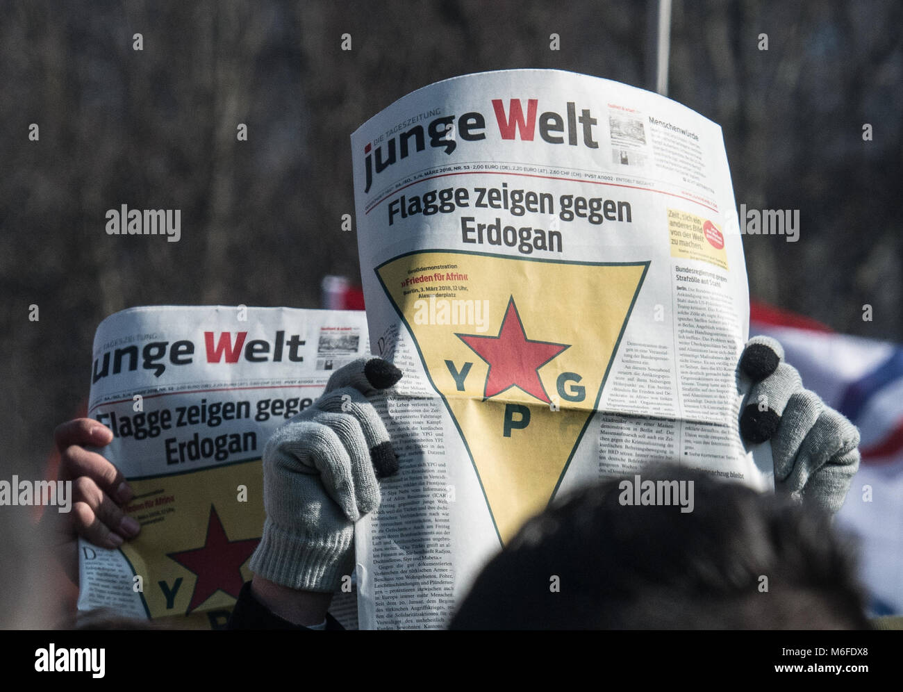 03 März 2018, Deutschland, Berlin: Menschen halten Zeitungen bei einer Demonstration von türkischen Aggressionen in der syrischen Provinz Afrin, wo die Mehrheit der Bevölkerung kurdischen ausgelöst. Foto: Paul Zinken/dpa Stockfoto