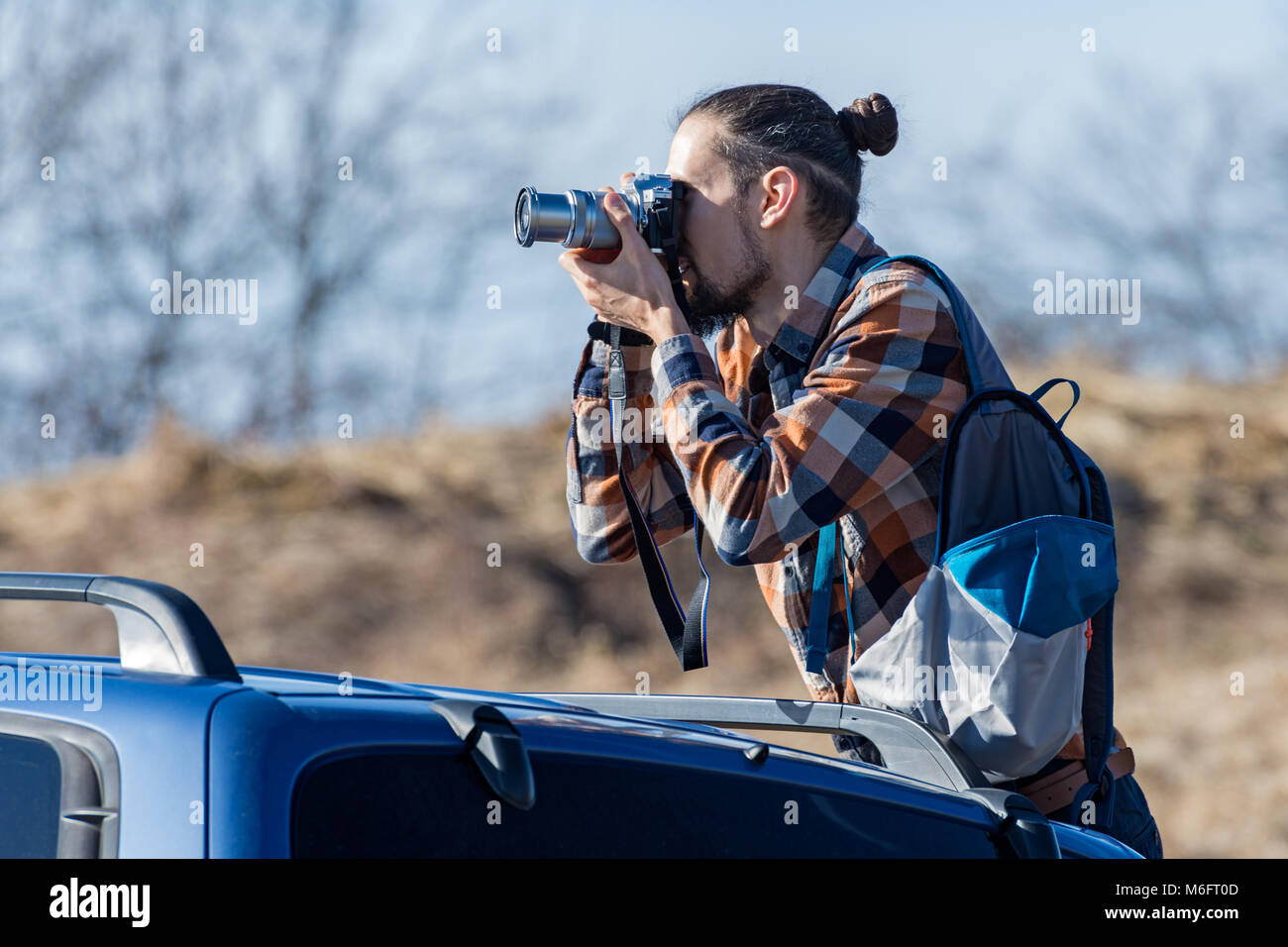 Der junge Mann ist das Schießen aus dem Auto Stockfoto