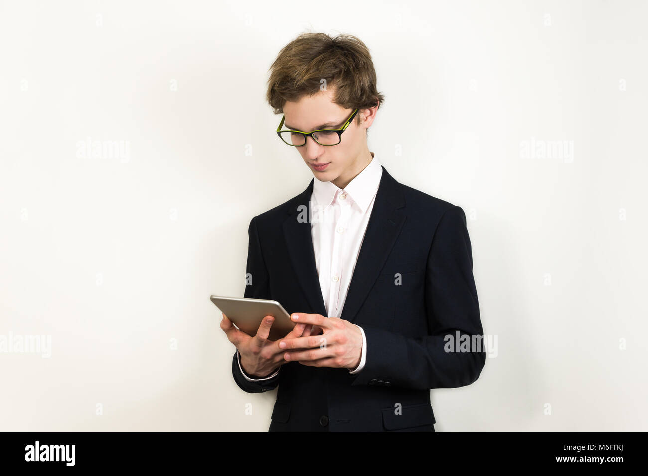 Junge erfolgreiche und selbstbewusste Business männliche Person Kontrolle Nachrichten oder Informationen in Tablet-PC. Stockfoto